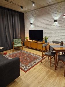 蒂科钦Apartamenty LOFTykocin的客厅配有电视和桌椅