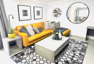 波罗瓜尼Lemon Ivy Guesthouse的客厅配有黄色的沙发和桌子