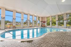 格兰德港Baymont by Wyndham Grand Haven的一座带窗户的大型建筑中的游泳池