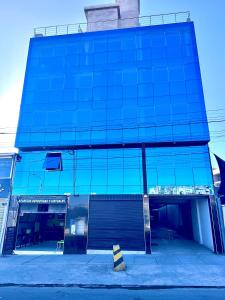 La ApachetaHOTEL DORADO AREQUIPA的一座带停车场的蓝色玻璃建筑