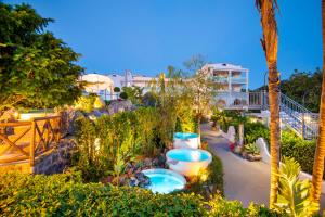 伊斯基亚Hermitage Resort & Thermal Spa的花园内带两个热水浴池的度假酒店