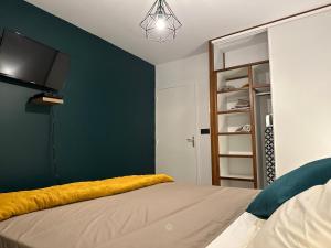 Rémire-CampLe petit colibri的一间卧室配有一张床,墙上配有电视