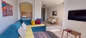 赫尔格达Villages road & promenade apartments的客厅配有蓝色的沙发和电视