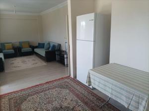 吉雷松Denize 3km Daire - Piraziz Giresun的客厅配有白色冰箱和沙发