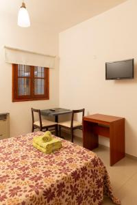 圣路易斯El Amparo Hotel的一间卧室配有一张带桌子和桌子的床。