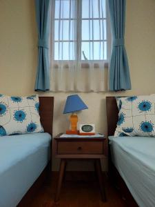 八王子市Guest house with host Takao SORA- Vacation STAY 13000的一间卧室配有两张床和一张带台灯的桌子