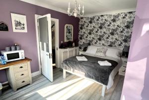 科克HighTree House的一间卧室设有紫色的墙壁、一张床和一台微波炉
