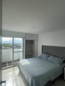 佩雷拉Altavista Apartamento Lindo y Comodo Piso 8 en Pereira的一间卧室设有一张床和一个大窗户