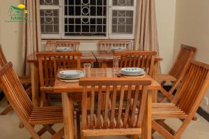 恩德培Miika Guest House的木制餐桌,配有四把椅子和一张桌子