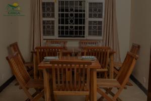 恩德培Miika Guest House的一间带木桌和椅子的用餐室