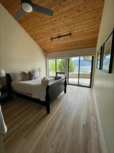 West KelownaLake House at Quails' Gate Winery的一间卧室设有一张带木制天花板的大床