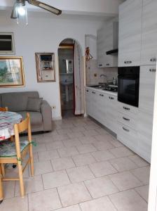 特罗佩阿Casa Vacanze Calabria的一间带桌子和沙发的厨房以及一间带桌子的厨房。