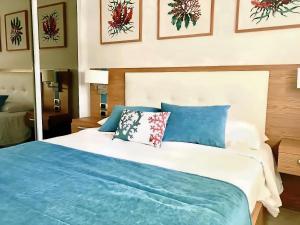 蓬塔卡纳Cana Rock Condos Penthouse Vista Espectacular Golf & Jacuzzi B-336 y B-330的一间卧室配有一张带蓝色枕头的大床