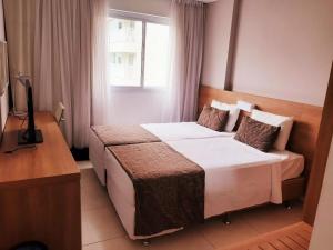 里约热内卢MELHOR LOCALIZAÇÃO NA BARRA DA TIJUCA- Apartamento com Ar, wifi, microondas的酒店客房设有两张床和电视。