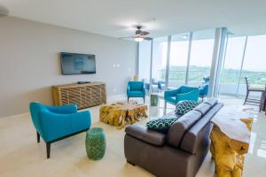 ArraijÃ¡n23o Penthouse Stunning Oceanview Resort Lifestyle的客厅配有沙发和蓝色椅子