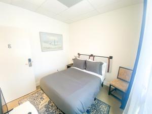 圣巴巴拉ITH Santa Barbara Beach Hostel的白色卧室配有床和椅子