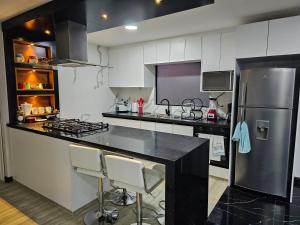 昆卡apartamento de lujo的厨房配有黑色柜台和冰箱。
