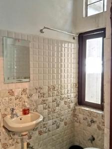 斋浦尔Cocoon Auberge的一间带水槽和卫生间的浴室以及窗户。