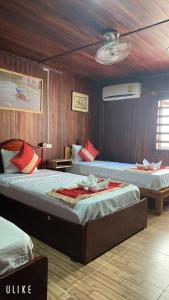琅勃拉邦Villa Thavisouk Legend - Luang Prabang的木墙客房的两张床