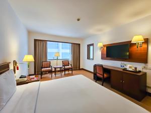 曼谷曼谷华美达迪马阁酒店的配有一张床和一张书桌的酒店客房