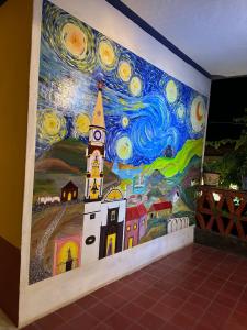 马斯科塔Copa de Oro Hotel Boutique的挂着建筑壁画的墙壁和钟楼