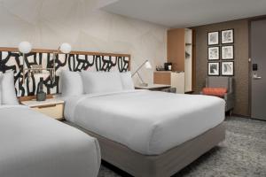 皇后区SpringHill Suites by Marriott New York Queens的酒店客房,配有两张床和椅子