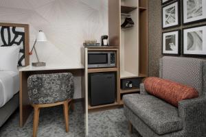 皇后区SpringHill Suites by Marriott New York Queens的酒店客房配有一张床、一张桌子和一把椅子。