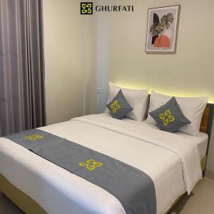 雅加达Ghurfati Hotel Wedana的一间卧室配有两张带黄灰色枕头的床