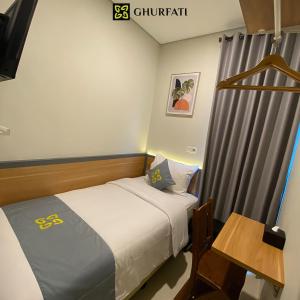 雅加达Ghurfati Hotel Wedana的一间小卧室,配有一张床和一张桌子