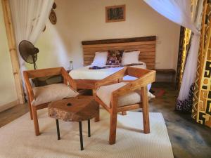阿鲁沙Haradali's Home的一间卧室配有一张带桌子和椅子的床