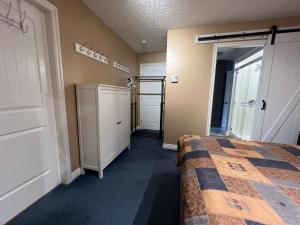 RoystonLittle Bear Garden View Suites-Hummingbird的一间卧室配有一张床和一个衣柜