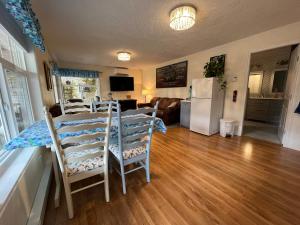 RoystonLittle Bear Garden View Suites-Hummingbird的厨房以及带桌椅的起居室。