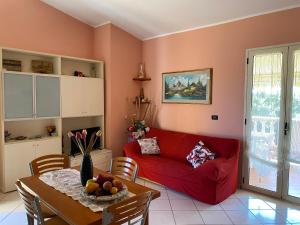 伊索拉迪卡波里祖托Residenza il sole isola Capo Rizzuto的客厅配有红色的沙发和桌子