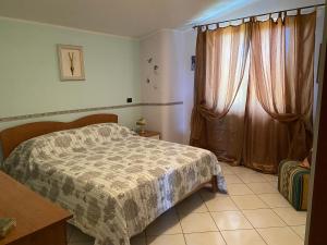 伊索拉迪卡波里祖托Residenza il sole isola Capo Rizzuto的一间卧室配有床和带窗帘的窗户