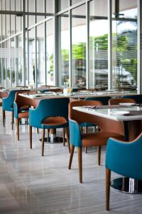 新德里新德里国际机场假日旅馆的用餐室设有桌椅和窗户。
