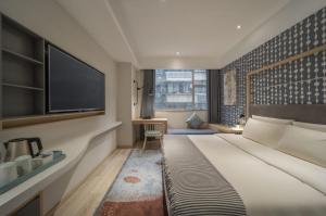 广州希诺酒店·广州北京路省人民医院店的一间卧室配有一张大床和一台平面电视