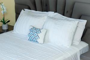 利隆圭Acacia Stay的白色的床和白色枕头顶部