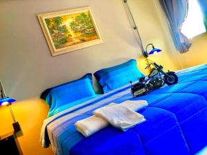 蔻立khaolak big bike&room for rent的一间卧室配有一张蓝色的床,上面装有摩托车