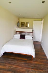 BadseyMyrtle的卧室配有一张白色大床,铺有木地板