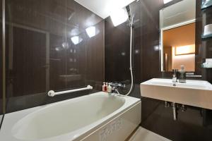 和歌山和歌山城市酒店的浴室配有白色浴缸和水槽