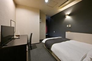 和歌山和歌山城市酒店的一间卧室配有一张床和一张带电脑的书桌