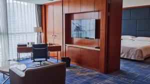 苏州苏州福朋喜来登酒店的酒店客房设有一张床、一张书桌和一台电视机。