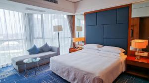 苏州苏州福朋喜来登酒店的一间卧室配有一张大床和一张沙发