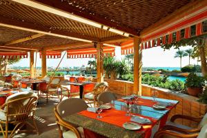 赫尔格达Hurghada Marriott Beach Resort的一间设有桌椅的海景餐厅