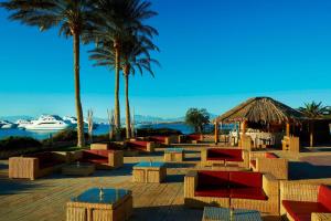 赫尔格达Hurghada Marriott Beach Resort的拥有桌子和棕榈树的度假村,拥有一艘船