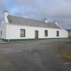 多尼戈尔Biddys cottage的白色的建筑,有黑色的屋顶