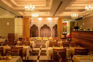 迪拜Four Points by Sheraton Bur Dubai的用餐室配有桌椅和吊灯。