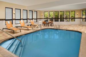 拉夫金拉夫金万怡酒店的游泳池位于酒店客房内,配有椅子和桌子