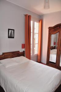 巴黎魏尔伦酒店的卧室配有一张白色大床和镜子