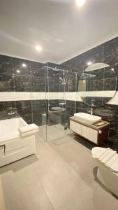 LaweanSolo Grand City的带浴缸、水槽和淋浴的浴室
